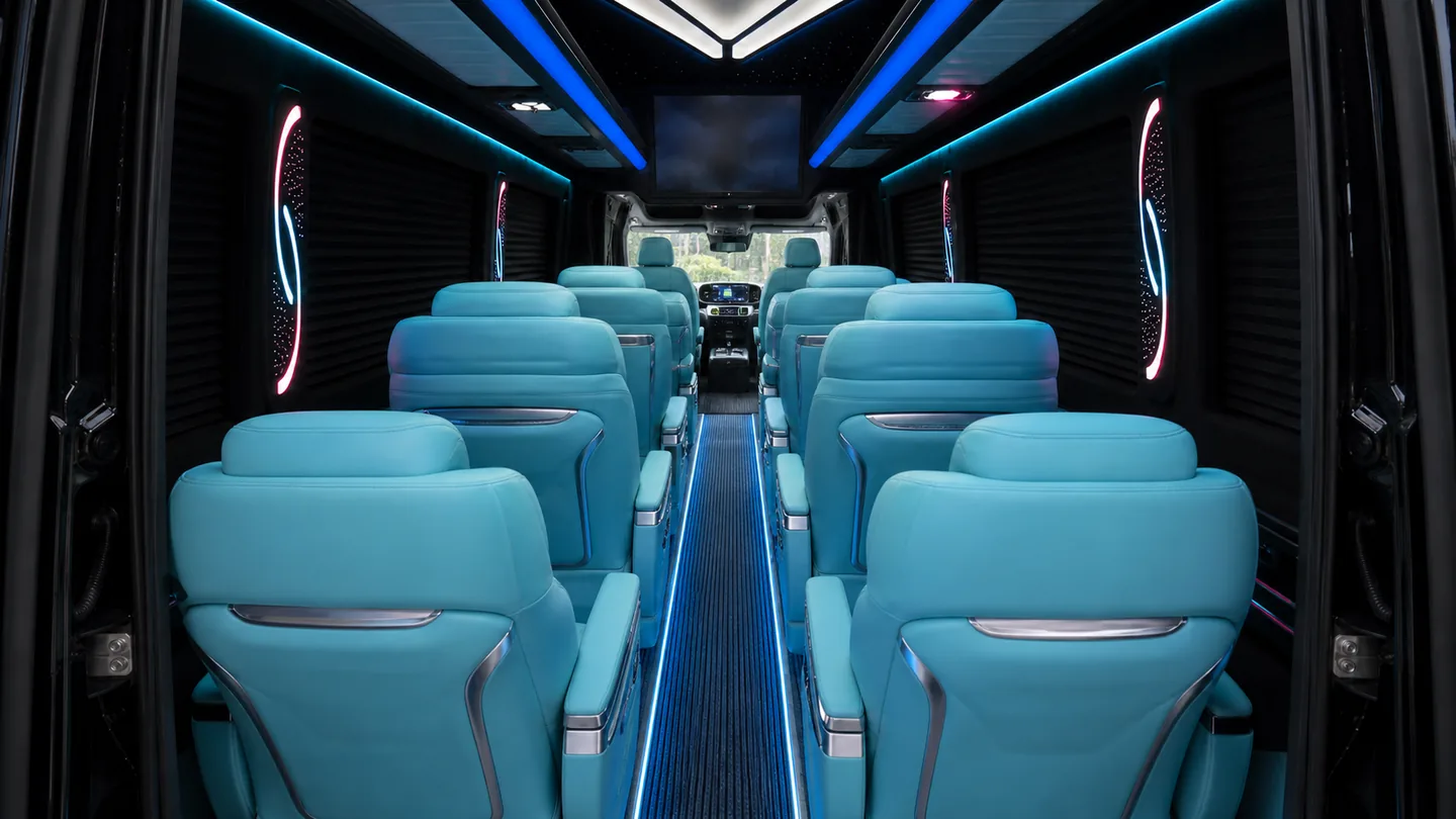 Wnętrze minibusa z niebieskim podświetleniem i turkusowymi fotelami