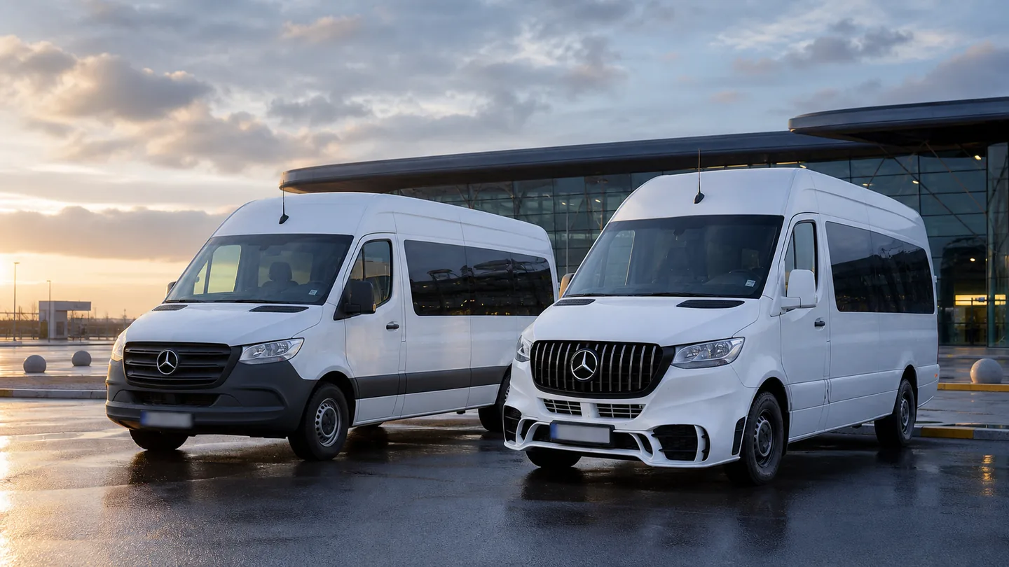 Dwa białe minibusy Mercedes Sprinter ComfortBus obok siebie przed terminalem o świcie